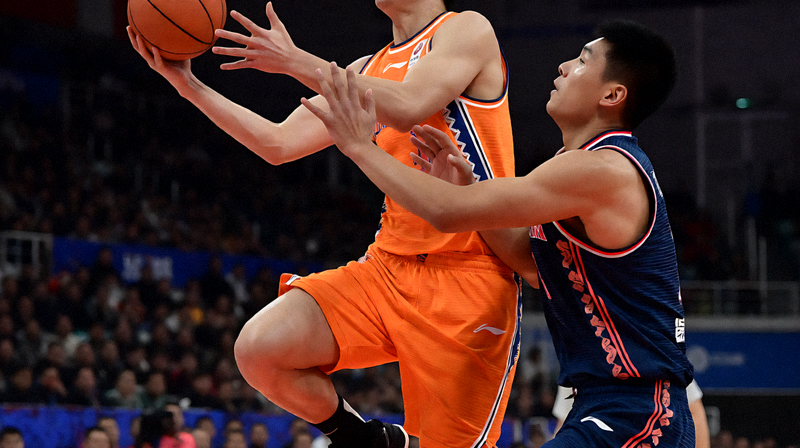 篮球比赛中球员突破上篮与防守球员对抗的画面